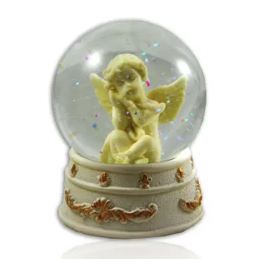 Boule à neige ange de face : l'ange, la joue dans la main, parmi les paillettes irisées