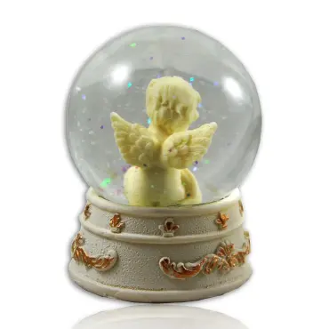 La boule à neige vue de dos : ailes de l'ange et frise de volutes dorées du socle