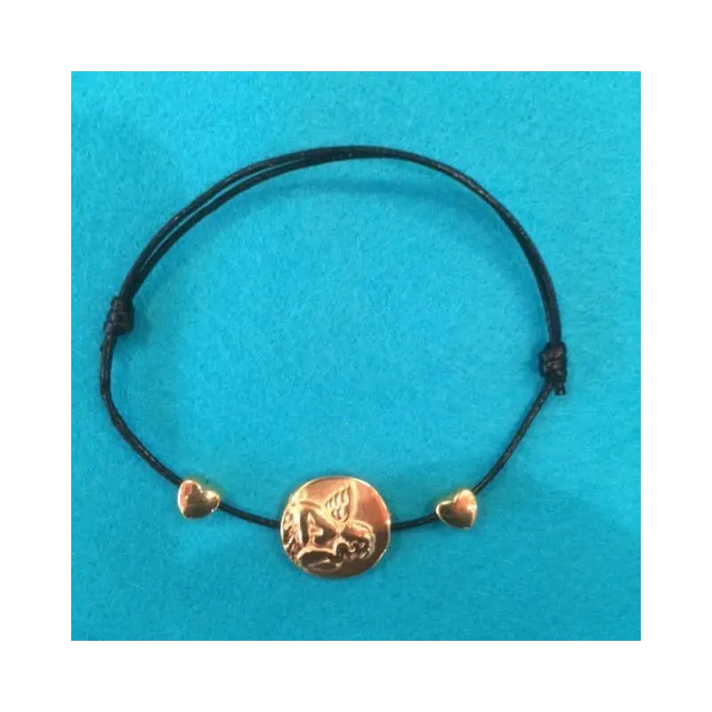 Bracelet médaille ange doré posé à plat sur feutrine turquoise, la médaille à l'angelot entre deux cœurs