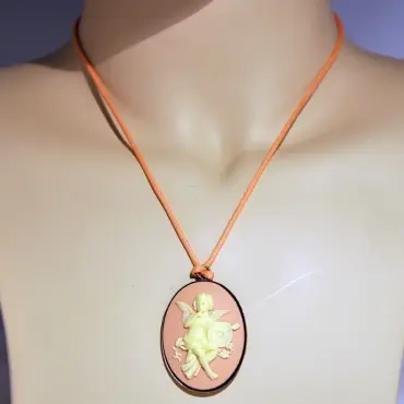 Collier camée rose porté sur un buste couleur chair, cordon orange