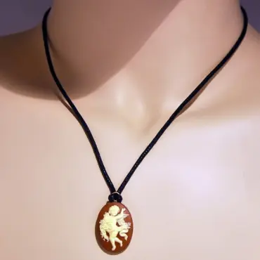 Collier camée « La Danse » ambre porté par un buste couleur chair, sur un cordon foncé