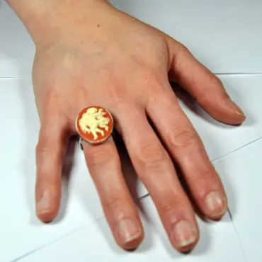Bague camée ambre portée à la main, pour juger de sa taille au doigt