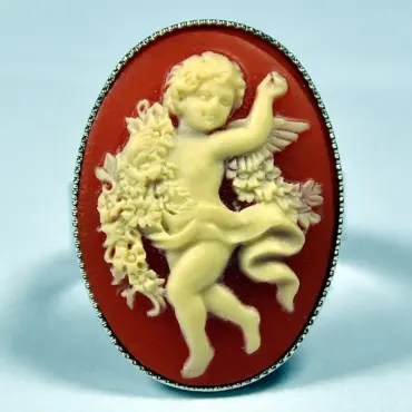 Bague au camée ambre vue de face, devant un fond bleu pâle