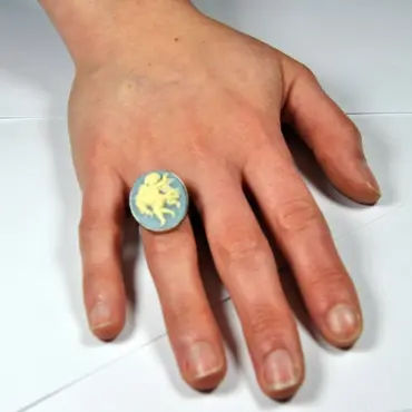 Bague au camée bleu clair portée sur une main posée à plat