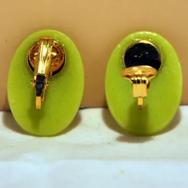 Dos des clips vert clair : l'un fermé, l'autre ouvert, attache dorée