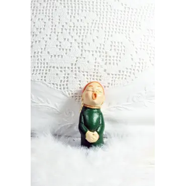 Devant un grand napperon au crochet, le petit choriste roux en robe verte, de face