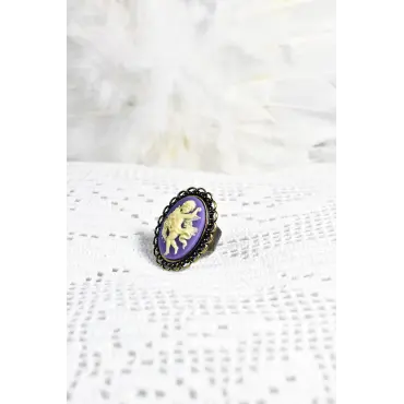 Bague au camée violet posée sur une dentelle au crochet