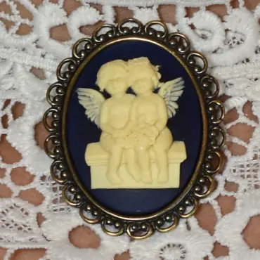 Le camée « Les Amoureux » sur fond bleu nuit, relief ivoire et bordure ajourée