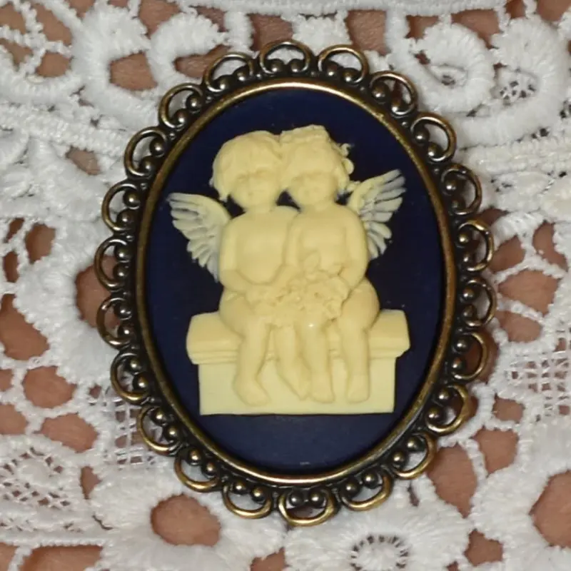 Le camée « Les Amoureux » sur fond bleu nuit, relief ivoire et bordure ajourée