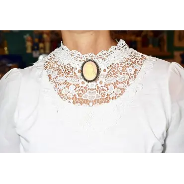 Broche « Les Amoureux » sur fond rose, portée au col d'un chemisier blanc