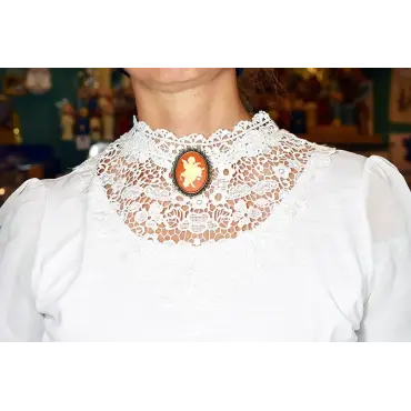 Broche ambre « L'Amour » portée sous le menton, sur un col en dentelle