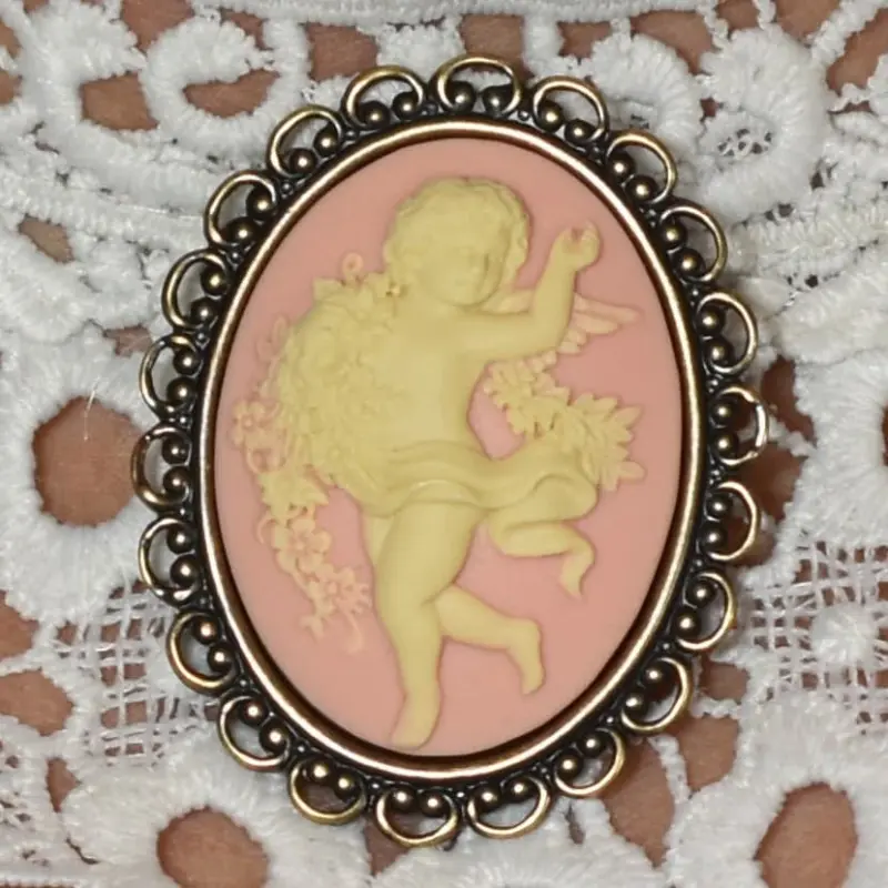Fond rose et monture dentelle vieux bronze autour de l'ange qui danse