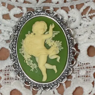 L'ange qui danse sur fond vert olive, dans sa monture dentelle vieil argent