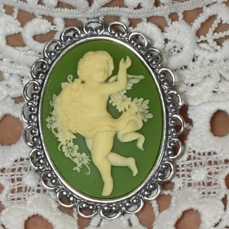 L'ange qui danse sur fond vert olive, dans sa monture dentelle vieil argent