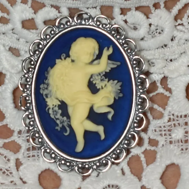 Broche « La Danse » sur fond bleu nuit, bordure de perles de métal et de boucles ajourées
