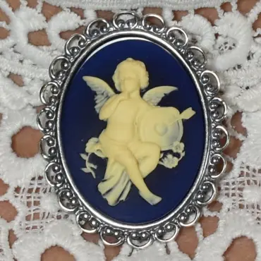 Fond bleu nuit et relief ivoire : l'ange, un doigt au menton, et sa cible percée d'une flèche