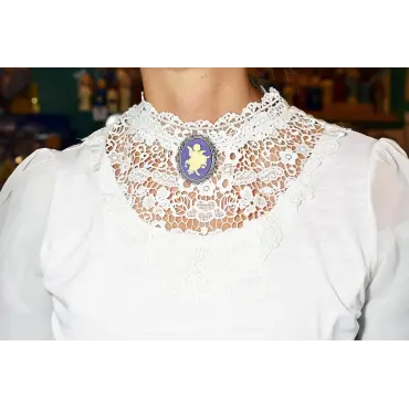 Fond violet de la broche « L'Amour », portée sur un chemisier blanc à col montant