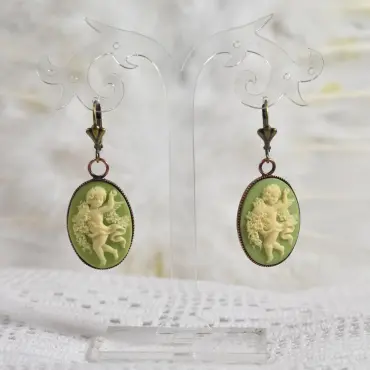 Boucles d'oreilles camée bronze vert clair, sur un présentoir transparent