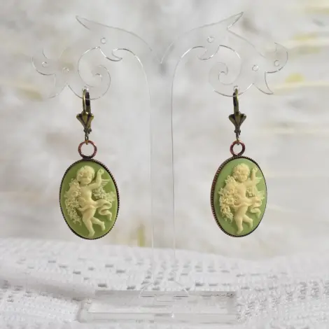Boucles d'oreilles camée bronze vert clair, sur un présentoir transparent