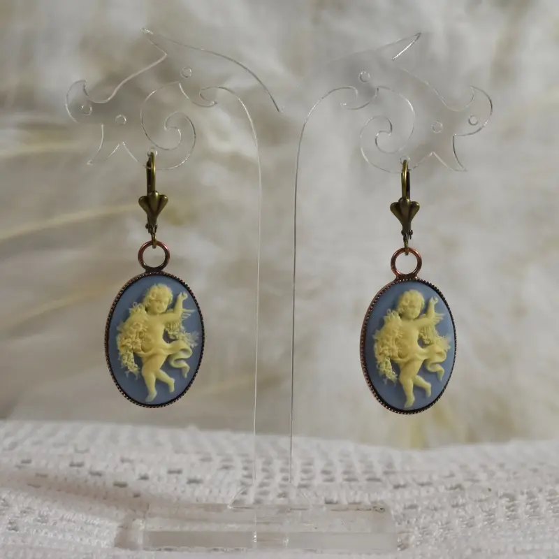 Pendants camée bleu clair au serti bronze, sur dentelle et plumes