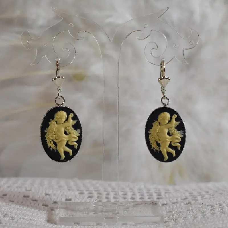 Paire de pendants camée noirs, devant des plumes blanches