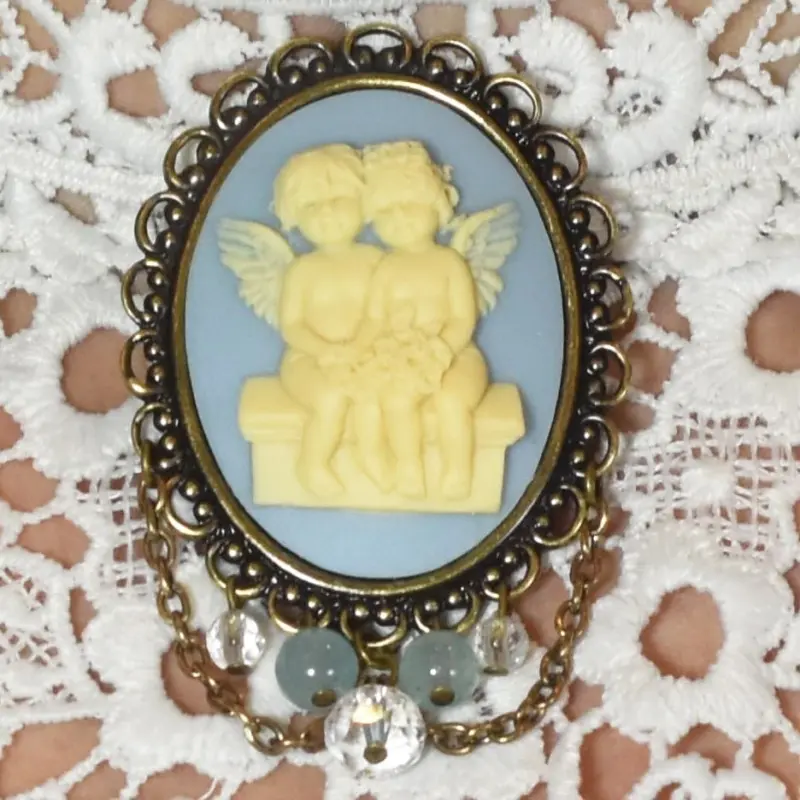 Broche châtelaine ange bleu clair, chaînettes couleur bronze en feston