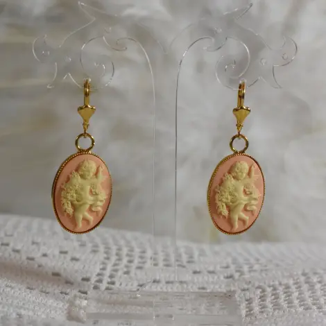 Pendants camée rose pêche au serti doré, sur fond de dentelle