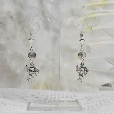 Boucles d'oreilles Cupidon avec une perle fumée, accrochées à un présentoir transparent