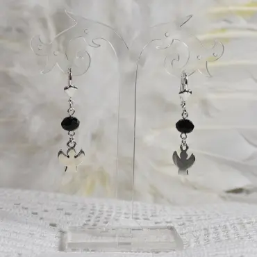 Boucles d'oreilles ange Silhouette, perle noire à facettes, sur un présentoir transparent