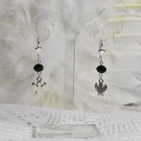 Boucles d'oreilles ange Silhouette, perle noire à facettes, sur un présentoir transparent