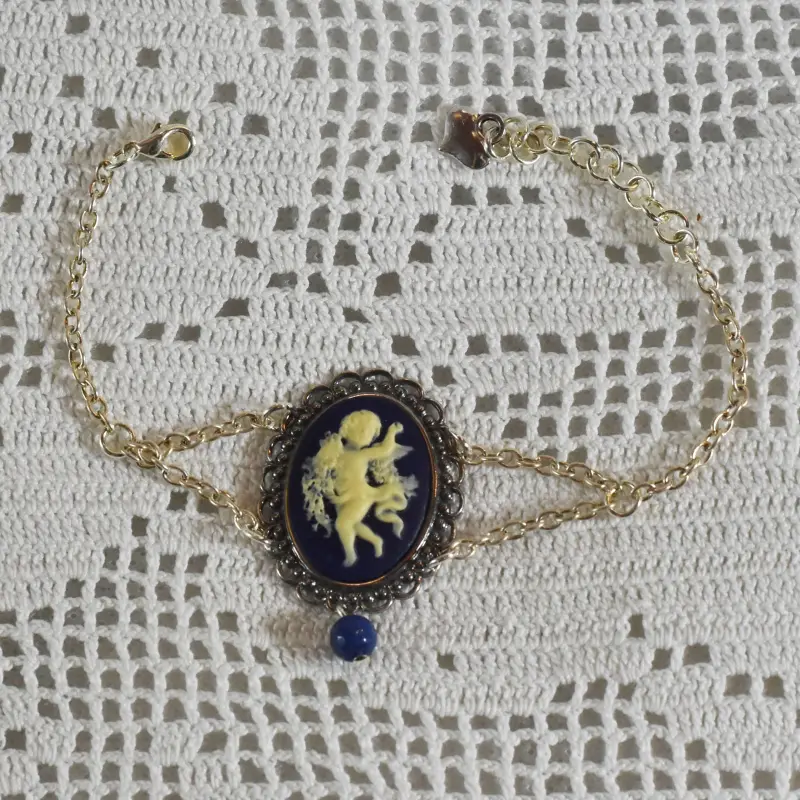 Bracelet camée bleu nuit à l'ange « La Danse », posé sur un napperon au crochet