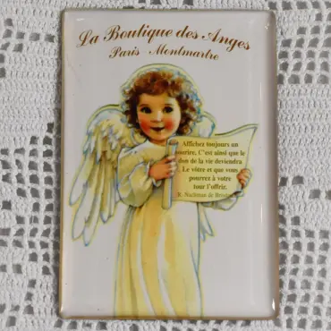 Aimant frigo Montmartre « Le Sourire » sur un napperon : angelot au parchemin, citation lisible