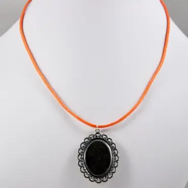 Pendentif rose retourné sur le buste, dos sombre et monture argentée
