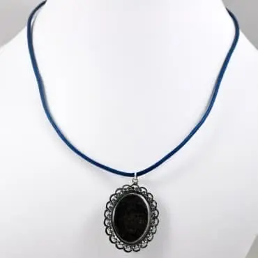 Collier bleu clair retourné sur le buste, dos gris foncé du pendentif