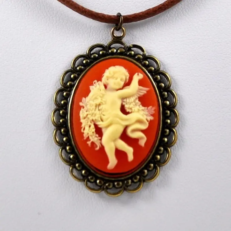 Camée ambre au fond rouge orangé, monture dentelle bronze vieilli