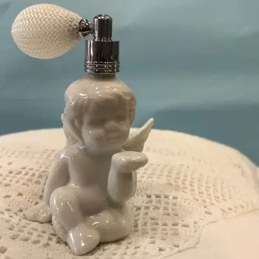 Vaporisateur Ange vu de face : angelot assis, main tendue, poire blanche gainée de filet