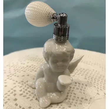 Flacon vaporisateur rechargeable en angelot, de trois quarts sur un napperon au crochet