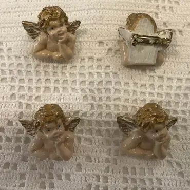 Quatre broches Raffaello sur dentelle au crochet : trois de face, une retournée sur son épingle