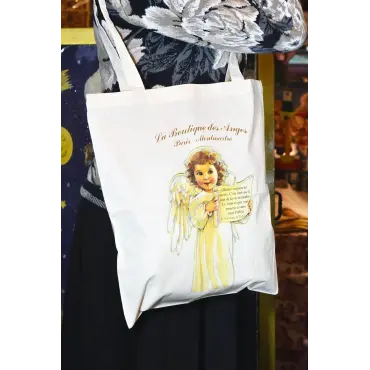 Sac « Le Sourire » en coton écru porté sur un haut noir à grandes fleurs blanches