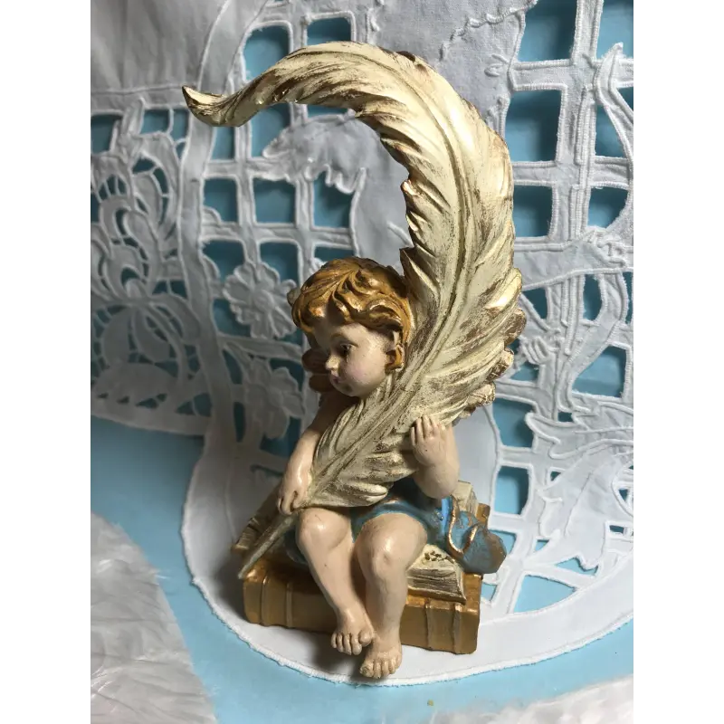 Statuette ange pensif de face, la plume contre l'épaule gauche, les yeux baissés