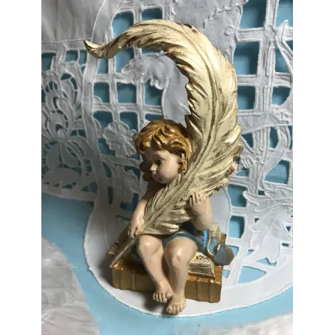 Statuette ange pensif de face, la plume contre l'épaule gauche, les yeux baissés